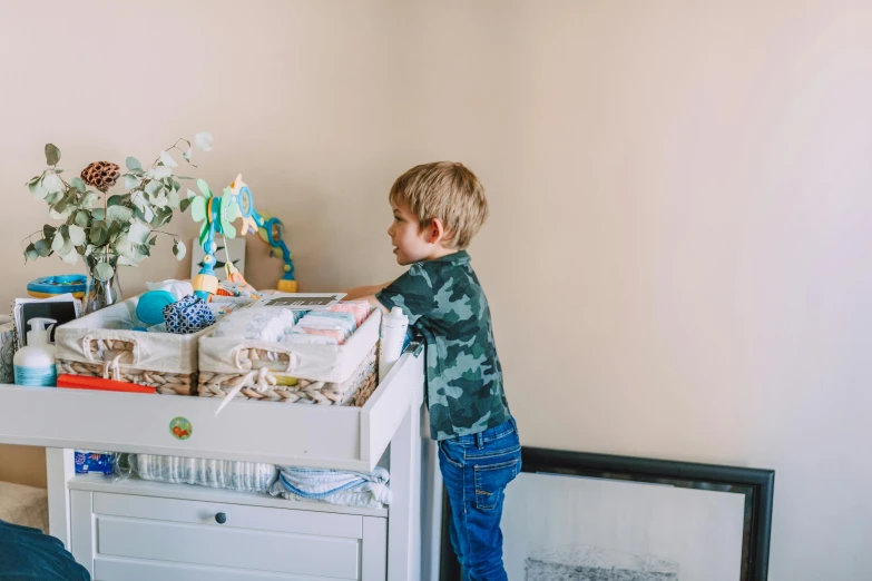 a little boy standing in front of a dresser, by Ruth Simpson, pexels contest winner, happening, diaper disposal robot, fully decorated, carrying a tray, stacked