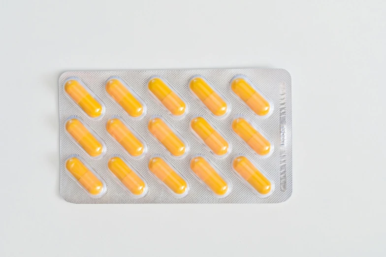 pills in a blister pack on a white surface, by Nicolette Macnamara, yellow orange, detailed product image, listing image, general