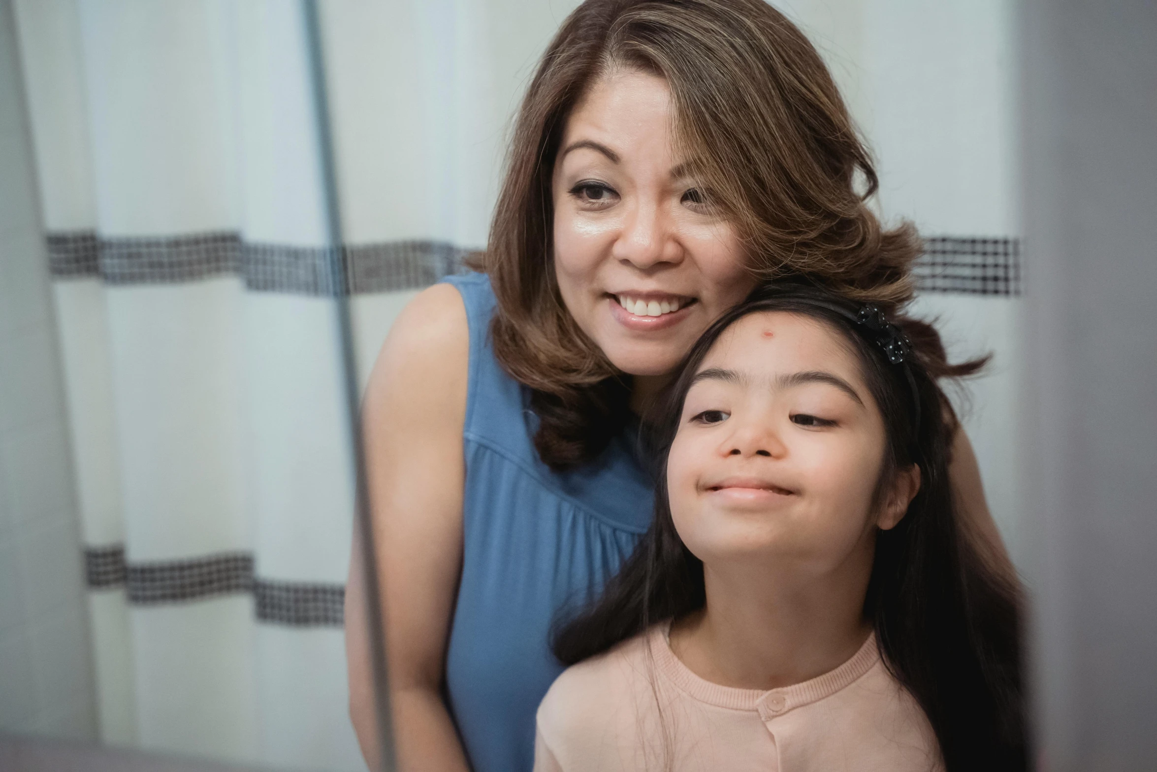 a woman standing next to a little girl in front of a mirror, inspired by Ruth Jên, pexels contest winner, hurufiyya, smiling slightly, avatar image, leni robredo, high angle close up shot