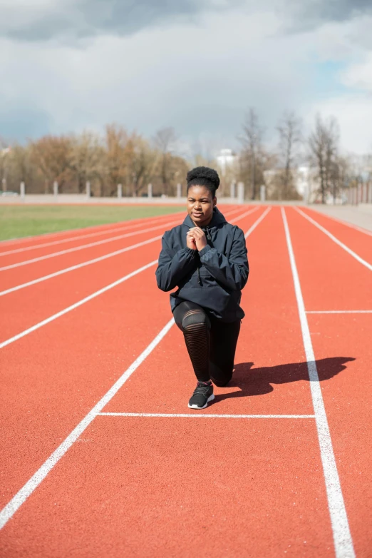 a man kneeling on a running track on a cloudy day, an album cover, pexels contest winner, renaissance, black young woman, 15081959 21121991 01012000 4k, plain background, aleksandra waliszewska