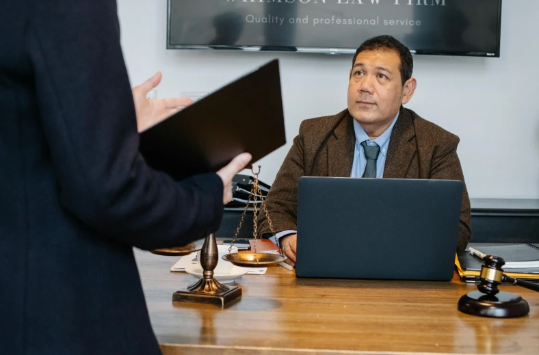 a man sitting at a desk in front of a laptop computer, by Simon Gaon, lawyer clothing, sam nassour, halation, thumbnail