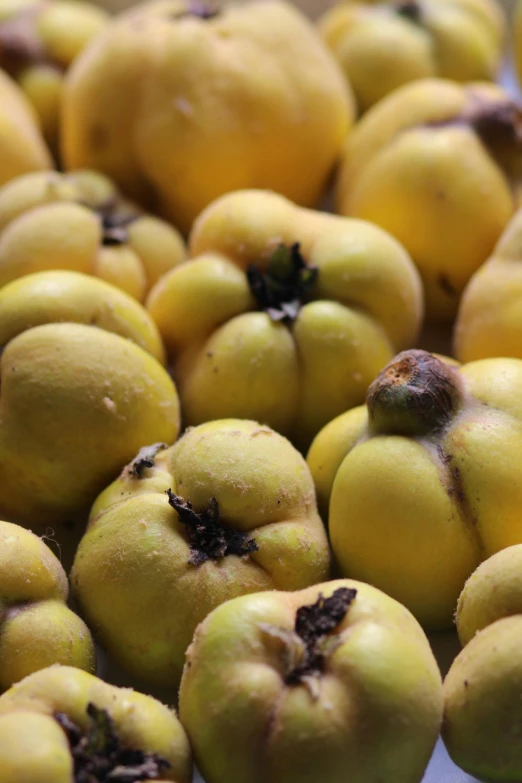 a pile of yellow fruit sitting on top of a table, huge chin, up close, thumbnail, local close up