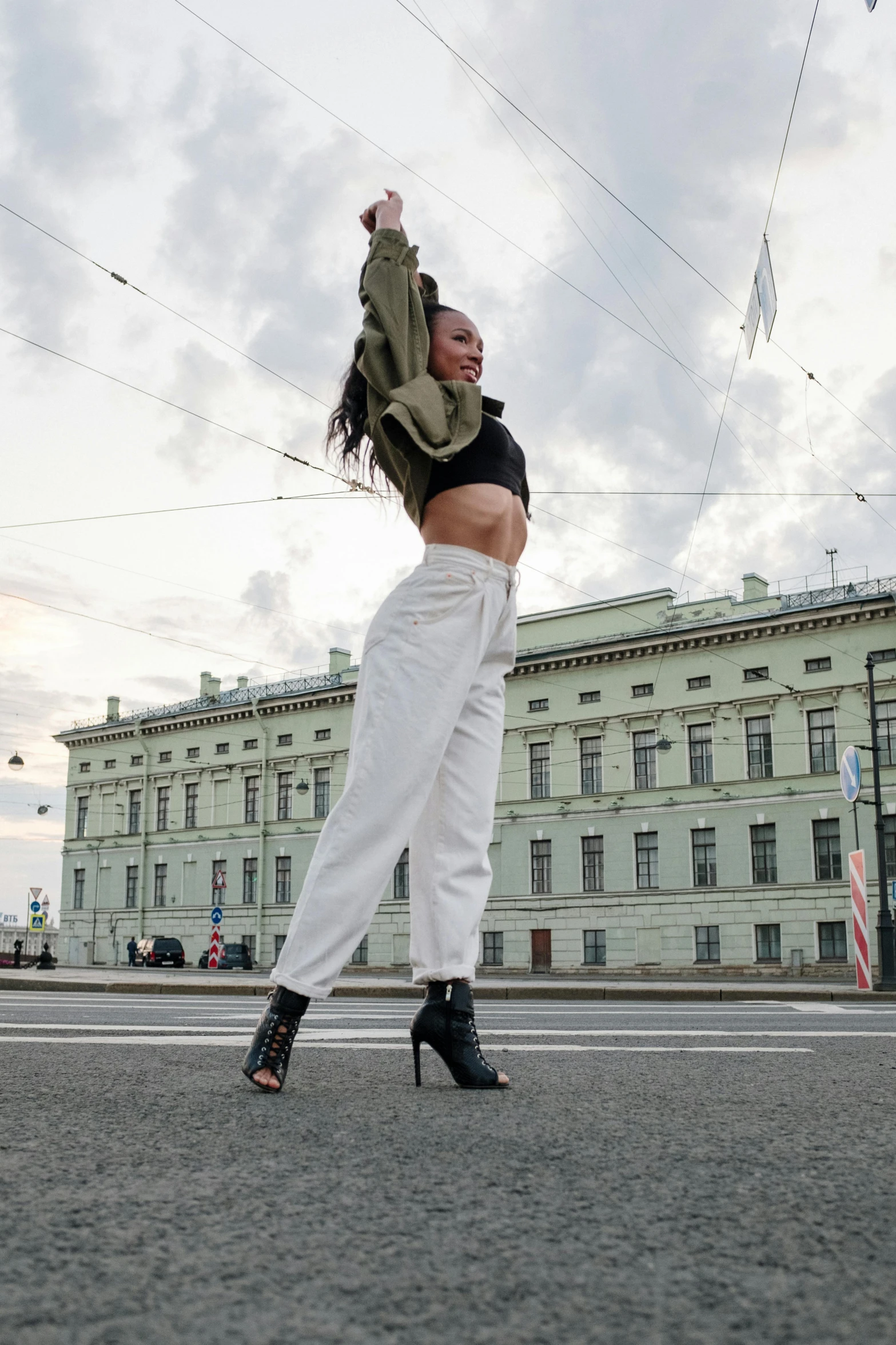 a woman in high heels jumping in the air, an album cover, pexels contest winner, street of moscow, baggy pants, non binary model, cold as ice! 🧊