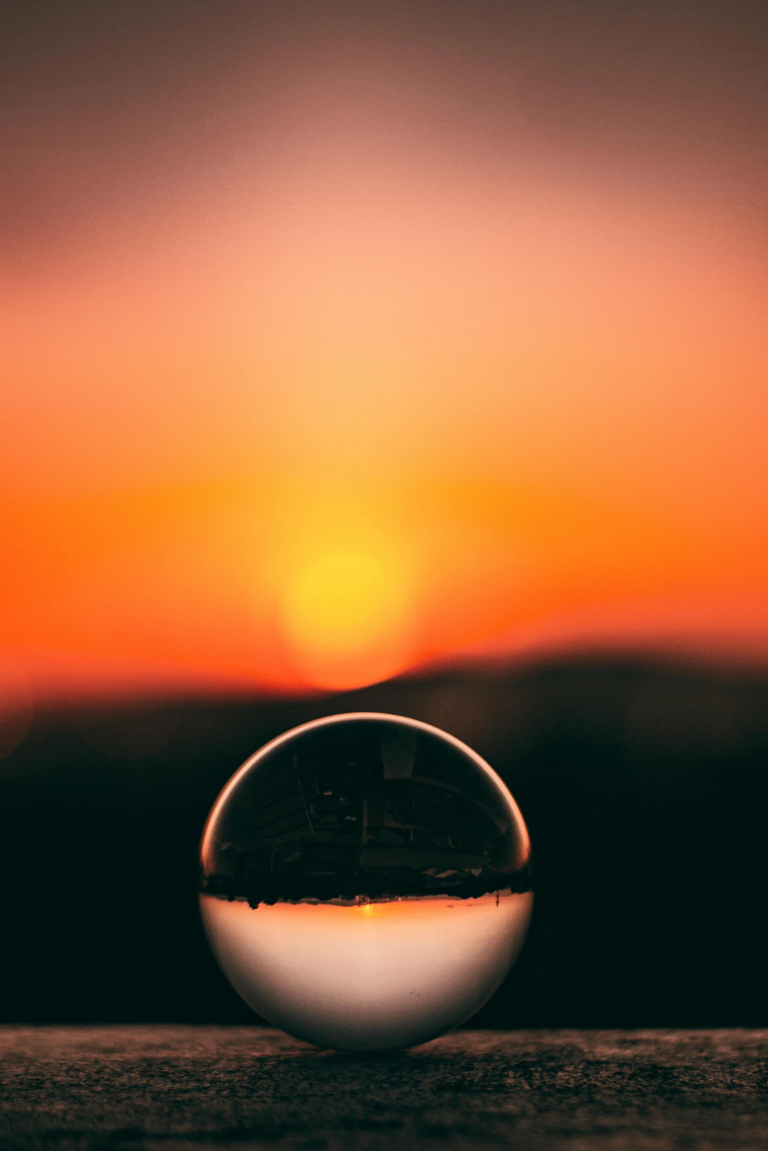 a glass ball sitting on top of a wooden table, a picture, unsplash, sunset photo, tilt shift”, vivid)