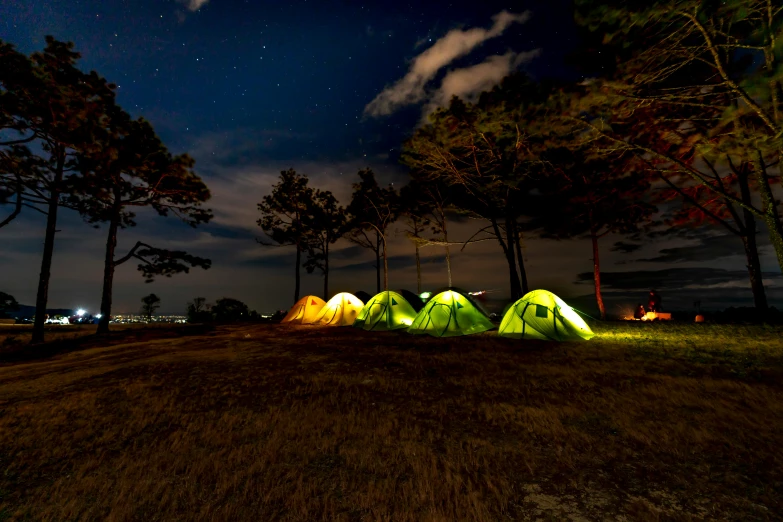 a group of tents sitting on top of a grass covered field, by Jan Tengnagel, pexels contest winner, outdoor lighting, manly, profile pic