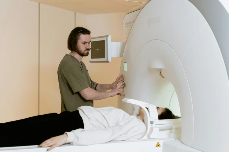 a man laying on a bed next to a mri machine, unsplash, male and female, “ iron bark, topographic scan, colour photograph