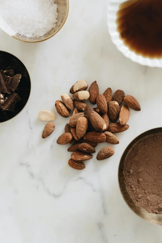 a table topped with a bowl of nuts and chocolate, by Jessie Algie, coffee, zoomed in shots, close-up product photo