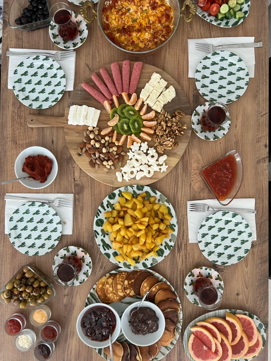 a wooden table topped with plates of food, a picture, ((oversaturated)), thumbnail, eating a cheese platter, turkey