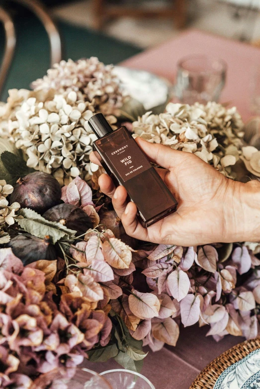 a person holding a cell phone next to a bunch of flowers, perfume bottle, deep earthy colours, thumbnail, jaquet droz