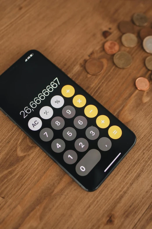 a cell phone sitting on top of a wooden table, mathematical, coins, thumbnail, yellow and black color scheme