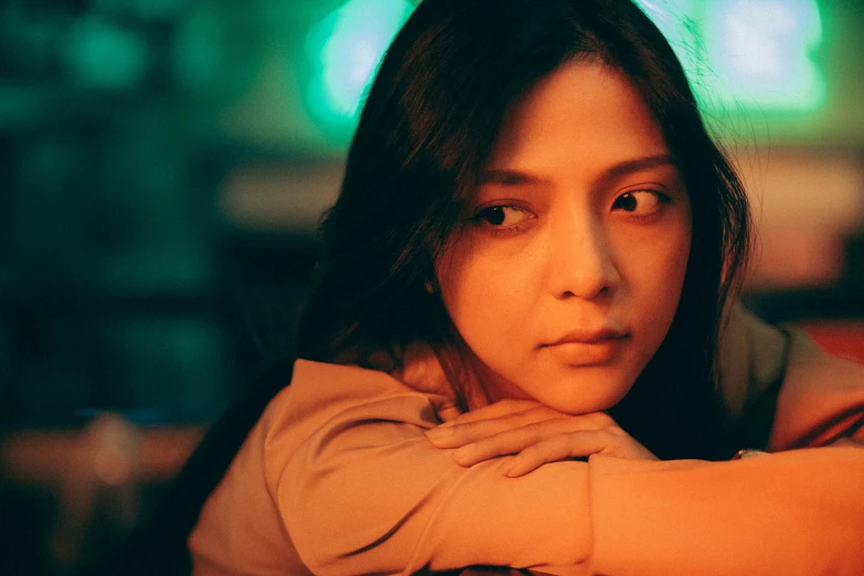 a close up of a person sitting at a table, a picture, inspired by Elsa Bleda, trending on pexels, renaissance, young asian girl, calm night. over shoulder shot, promotional image, tired expression