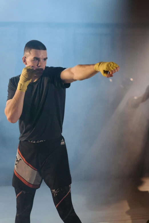 a man in a black shirt and yellow gloves, by William Berra, shutterstock, in fighter poses, square, drake, gal yosef