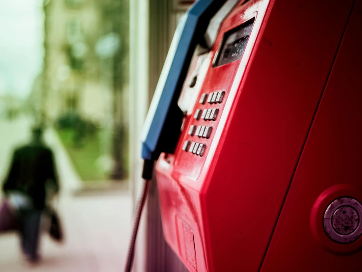 a red pay phone sitting on top of a sidewalk, pexels contest winner, multi - coloured, paul barson, close - shot, romanian