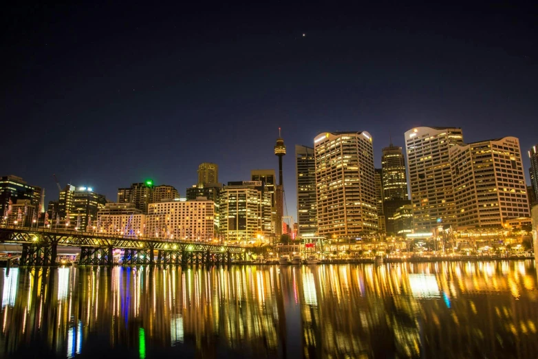 a city at night with lights reflecting in the water, inspired by Sydney Carline, pexels contest winner, post-processed, rob ross, harbour, upright