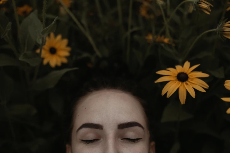 a woman laying in a field of flowers with her eyes closed, inspired by Elsa Bleda, pexels contest winner, surreal black and yellow, perfect symmetrical face, still frame from a movie, woman made of plants