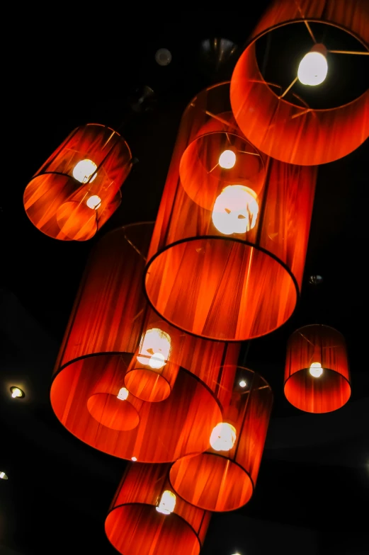 a bunch of red lamps hanging from a ceiling, by Doug Ohlson, light and space, beautifully soft lit, orange lights, soft shade, light art