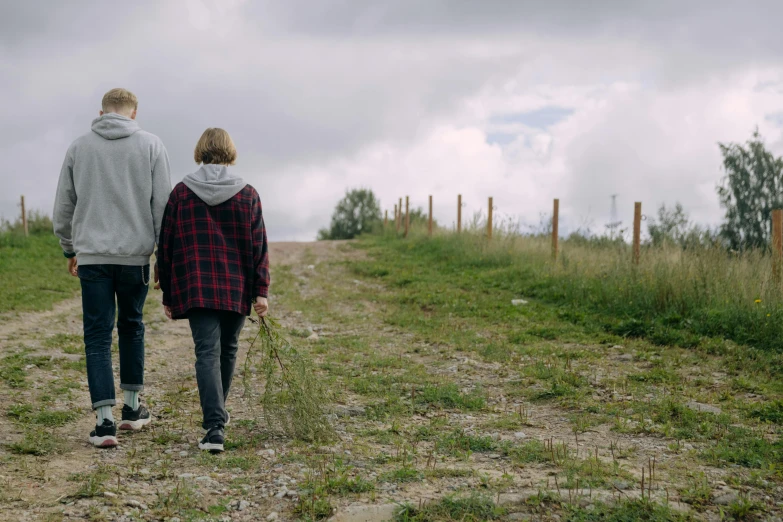 a man and a woman walking down a dirt road, by Jesper Knudsen, unsplash, teenage boy, grassy hill, comforting, cinema still