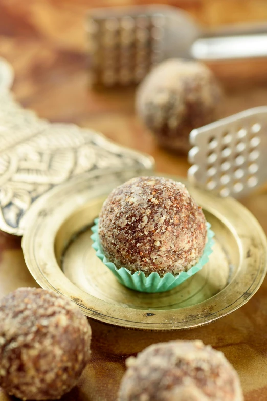 a close up of a plate of food on a table, cannonballs, egyptian setting, brown resin, gold madhubani