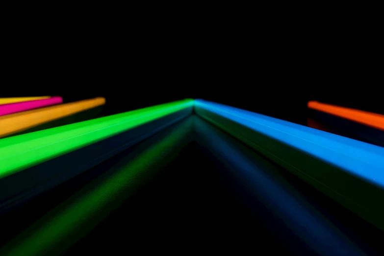 a group of neon sticks sitting on top of a table, unsplash, light and space, color highway, light coming from the right side, blue and green light, guillotine rgb