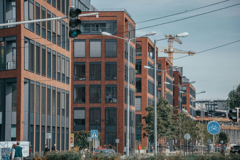 a street filled with lots of traffic next to tall buildings, by Tobias Stimmer, unsplash, modernism, hannover, brick, industrial architecture, ten flats