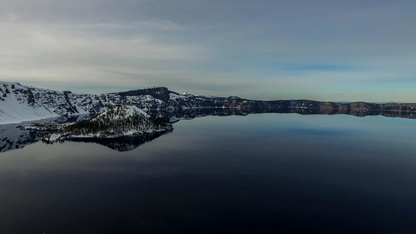 a large body of water surrounded by snow covered mountains, by Jim Nelson, pexels contest winner, renaissance, crater lake, calm afternoon, ultrawide angle, grey