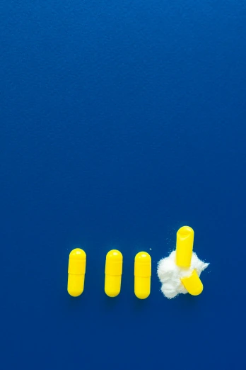 a pair of yellow ear plugs sitting on top of a blue surface, inspired by Yves Klein, process art, pills, white cloud, (digital art), shot from drone