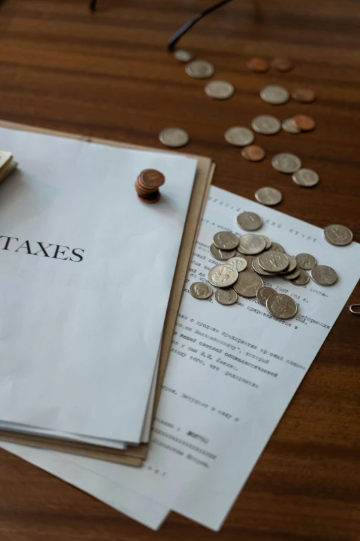 a stack of papers sitting on top of a wooden table, by Adam Rex, pexels contest winner, renaissance, with piles of coins around it, promo image, taejune kim, labeled