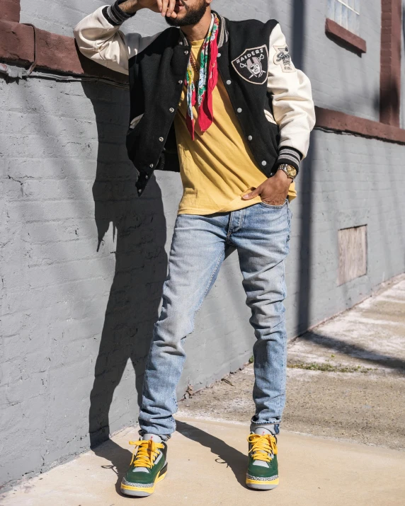 a man standing on a sidewalk talking on a cell phone, an album cover, inspired by Jean Micheal Basquiat, trending on unsplash, gang saints wear yellow bandanas, ( ( ( wearing jeans ) ) ), bomber jacket, model posing