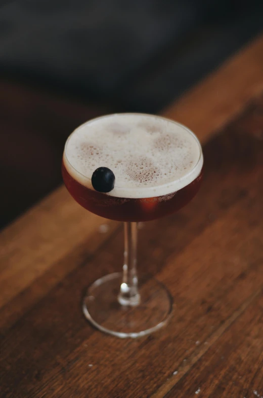 a drink sitting on top of a wooden table, by Ndoc Martini, renaissance, indigo, monocle, bubble head, southern cross