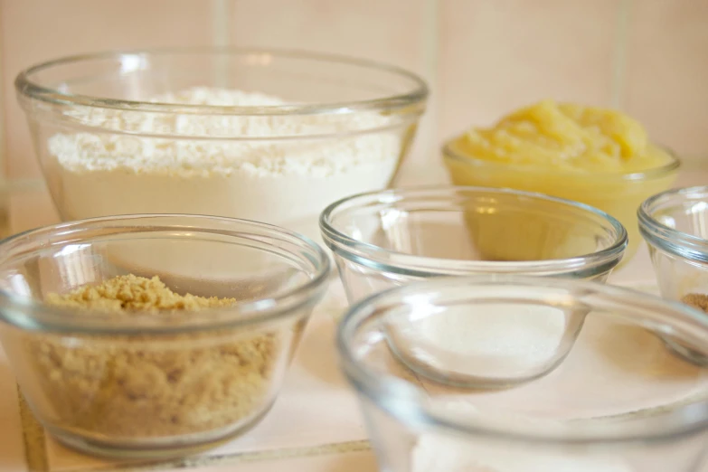 a number of bowls of food on a counter, pexels, process art, crust, cream, square, glassware