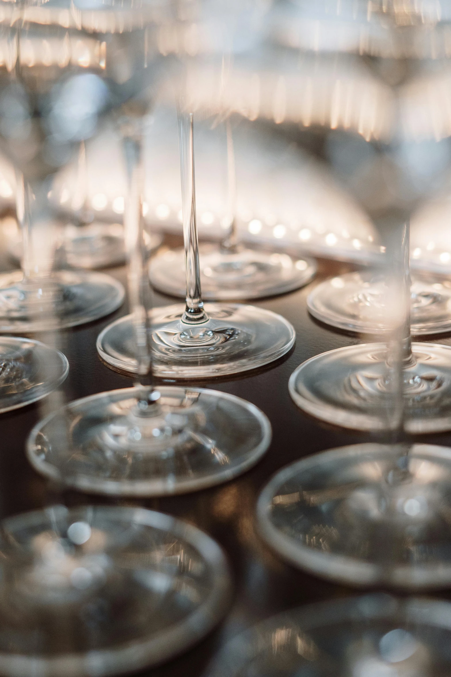 a bunch of wine glasses sitting on top of a table, by Carey Morris, lots of bubbles, soft lighting from above, subtle detailing, medium close up