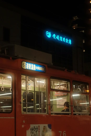 a red bus driving down a street next to a tall building, sōsaku hanga, orange and cyan lighting, sign, golden chinese text, trams ) ) )