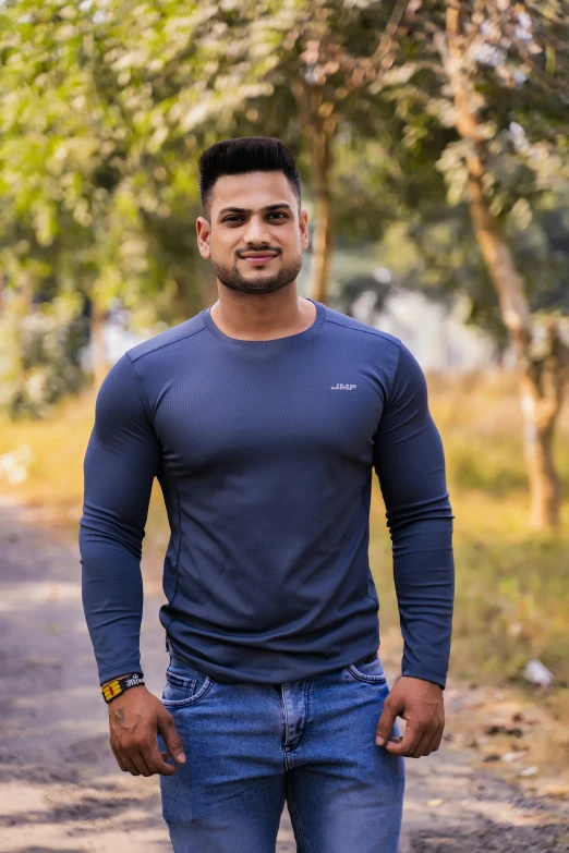a man standing in the middle of a dirt road, a screenshot, inspired by Saurabh Jethani, pexels contest winner, 2 muscular attractive men, in a navy blue sweater, frontal pose, wearing tight shirt