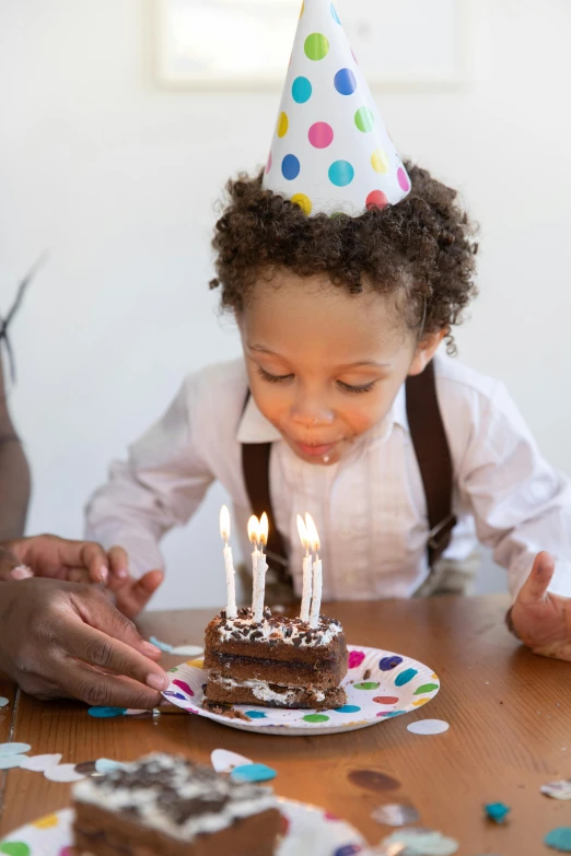 a little boy sitting at a table with a birthday cake, trending on unsplash, incoherents, white with chocolate brown spots, african american, ignant, pee wee herman