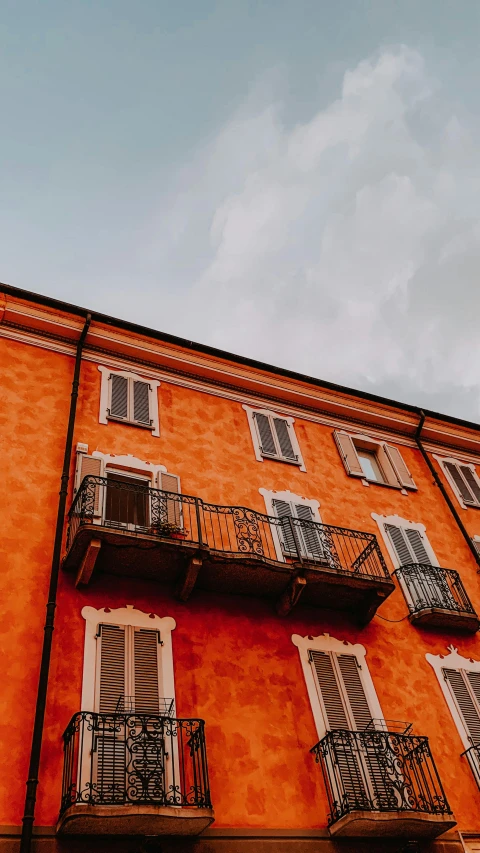 an orange building with balconies and balconies on the balconies, inspired by Michelangelo Buonarotti, pexels contest winner, low quality photo, bizzaro, youtube thumbnail, shot on sony a 7