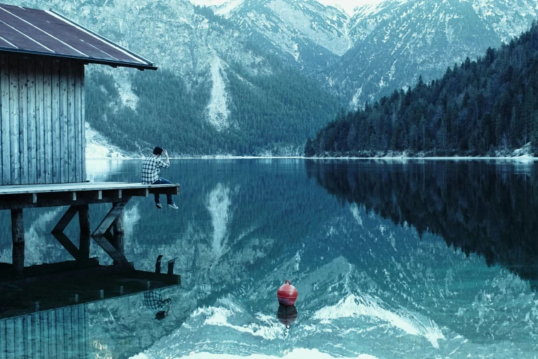 a red fire hydrant sitting in the middle of a lake, a picture, inspired by Oleg Oprisco, pexels contest winner, lakeside mountains, cold blue colors, lake house, mirrored