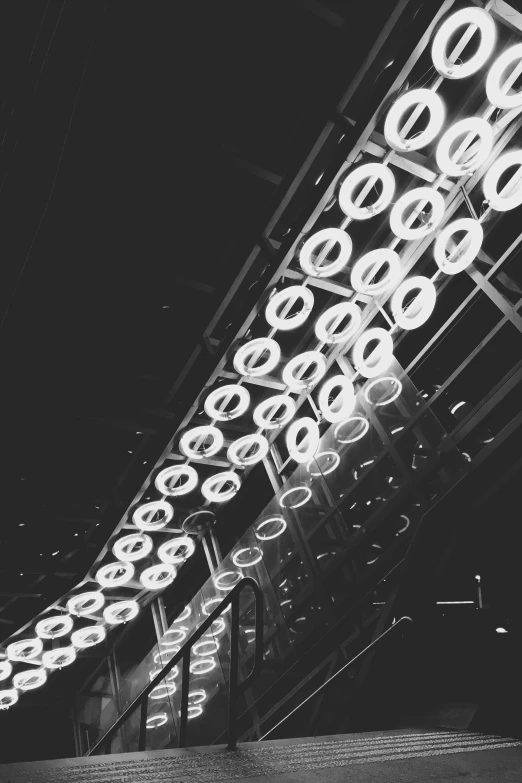 a black and white photo of a train station, inspired by Cerith Wyn Evans, light and space, neon circles, vsco, ceiling, lights