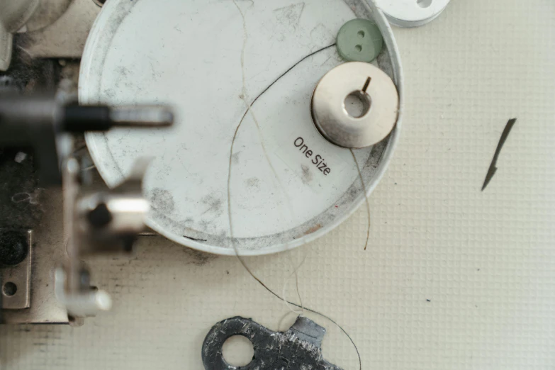 a sewing machine sitting on top of a table, inspired by James Paterson, trending on pexels, assemblage, close up shot of an amulet, circle forms, silver，ivory, grey