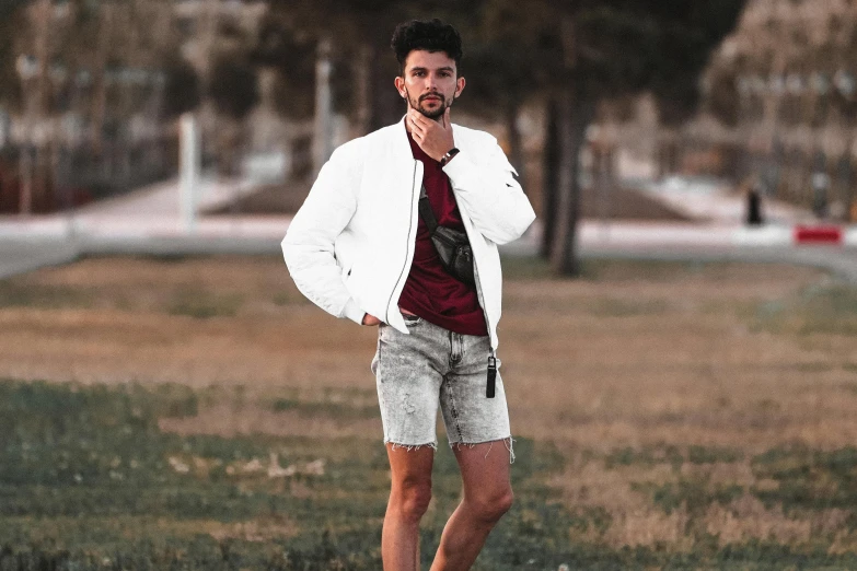 a man standing in a field talking on a cell phone, a colorized photo, pexels contest winner, renaissance, an aviator jacket and jorts, white fluffy cotton shorts, white t-shirt with red sleeves, jesus alonso iglesias