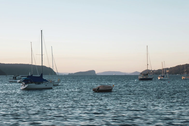 a group of boats floating on top of a body of water, inspired by Wilhelm Marstrand, pexels contest winner, sydney, late summer evening, med bay, te pae