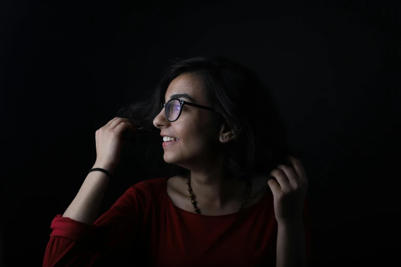 a woman in a red shirt is brushing her hair, a character portrait, by irakli nadar, pexels contest winner, hurufiyya, wearing black glasses, profile pic, backlighted, dayanita singh