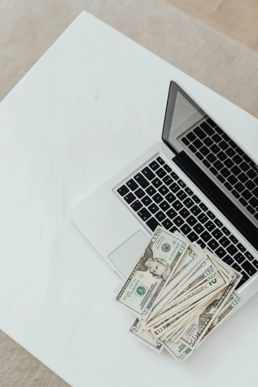 a laptop computer sitting on top of a white table, made of money, 🔞🤡, curated collections, - 9