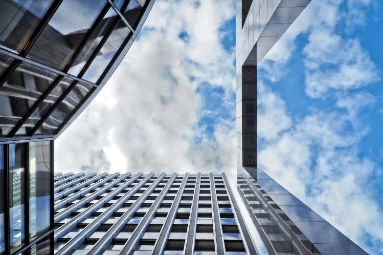 a very tall building with a lot of windows, inspired by Richard Wilson, pexels contest winner, modernism, clouds around, three towers, concrete steel glass, eyelevel perspective image