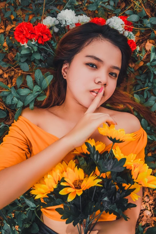 a woman laying on the ground holding a bunch of flowers, inspired by Elsa Bleda, unsplash contest winner, wearing yellow croptop, vietnamese woman, hand over mouth, 🤤 girl portrait