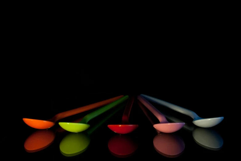 a group of spoons sitting next to each other, a digital rendering, by Doug Ohlson, minimalism, colored gel lighting, chopsticks, all colors, made of glowing wax and ceramic