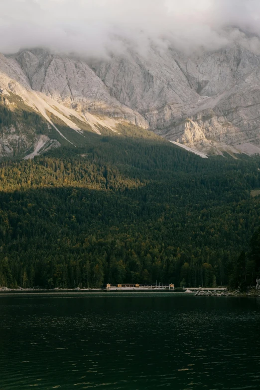 a large body of water with a mountain in the background, by Tobias Stimmer, trending on unsplash, moody : : wes anderson, lake house, late afternoon light, telephoto vacation picture