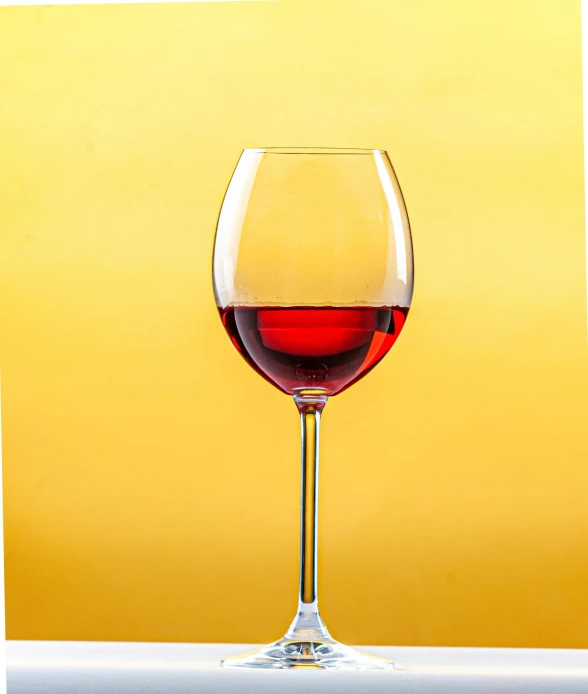 a glass of red wine sitting on a table, an album cover, by Jan Rustem, pexels contest winner, gradient yellow to red, slightly overexposed, cosmopolitan, 3945074687