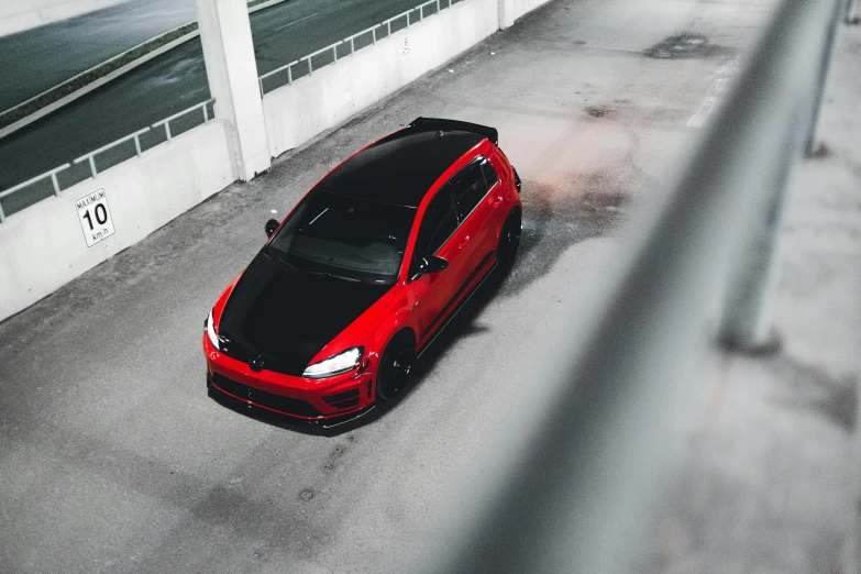 a red car is parked in a parking lot, a photo, by Adam Marczyński, black and red armor, high view, avatar image, mkbhd