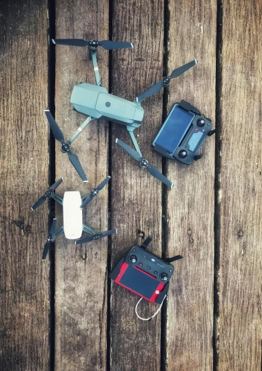 a couple of remotes sitting on top of a wooden floor, drone photograpghy, instagram post, flies, mini