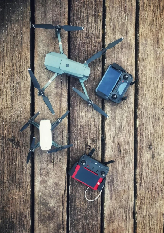 a couple of remotes sitting on top of a wooden floor, drone photograpghy, instagram post, flies, mini